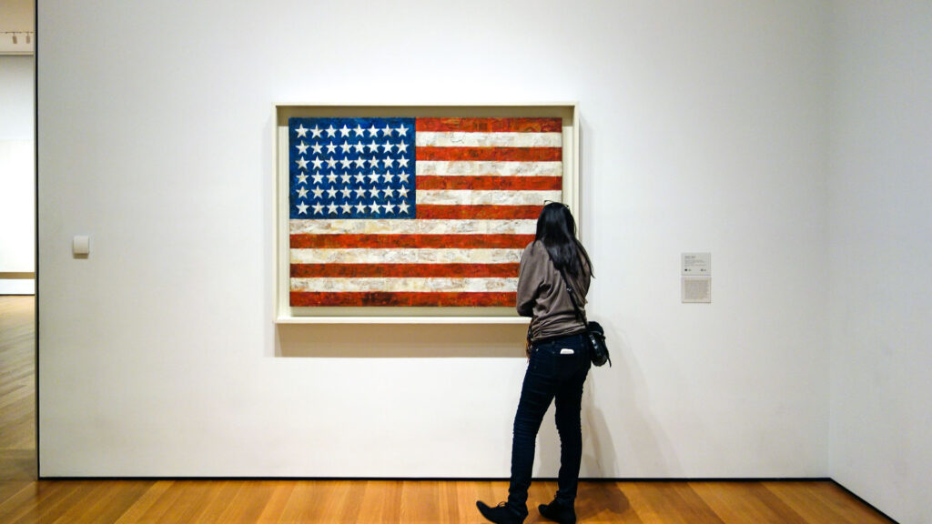 Designer Jasper John's American flag viewed by a museum patron.